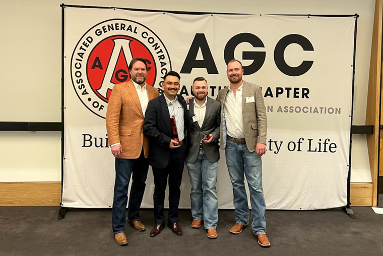 AGC ceremony backdrop · four-person portrait